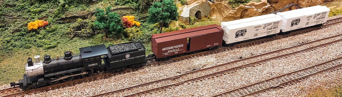 D&RGW #950 mogul steam locomotive pulls three wooden box cars.